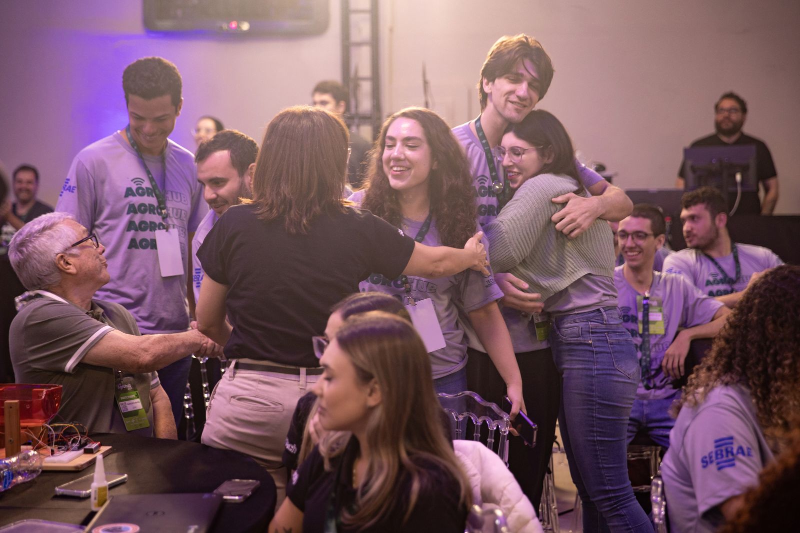 Participantes se abraçando no evento