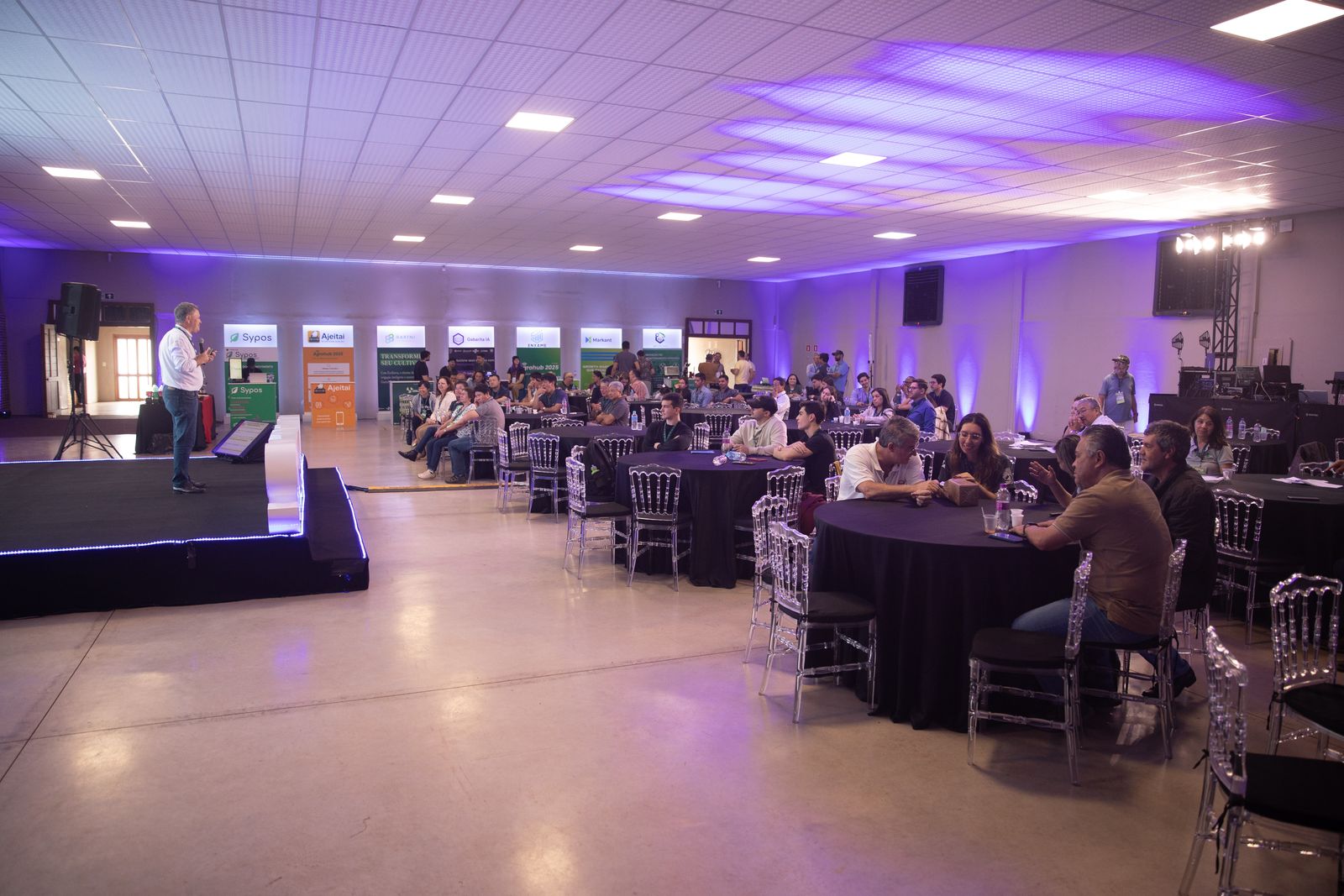 Salão do evento com público nas mesas